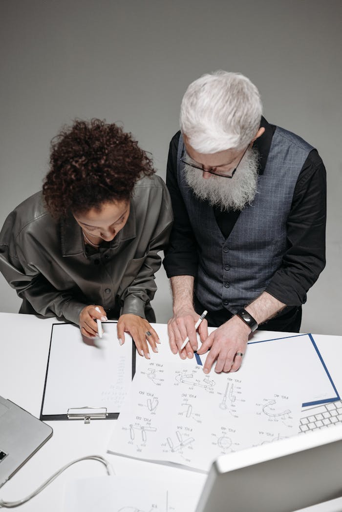 Top view of diverse colleagues collaborating over design drafts in a modern office.